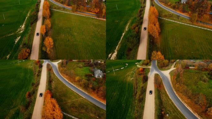 空中俯视图，相机跟随黑色汽车沿着乡村田野和黄色的秋树行驶，美丽的公路旅行。