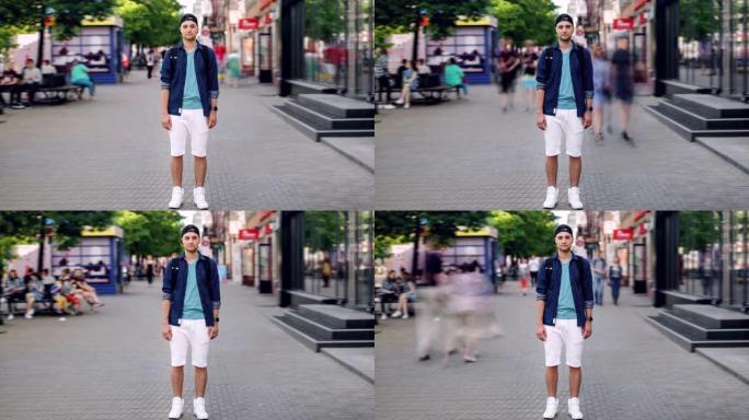 英俊男子站在市中心的街道上看着相机的延时