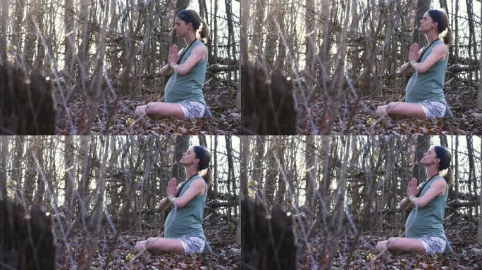 年轻孕妇在森林里练习瑜伽和正念
