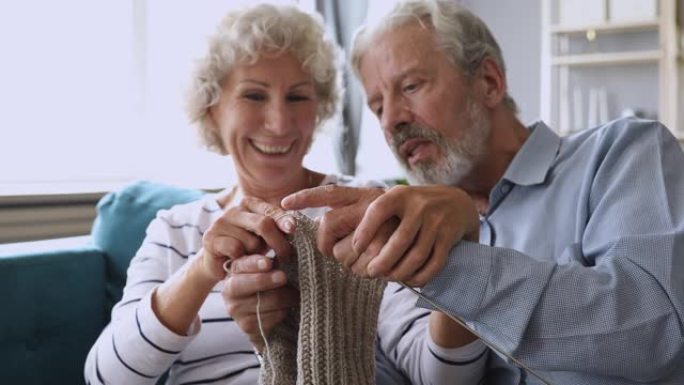 幸福的中年已婚夫妇编织手工灰色羊毛围巾。
