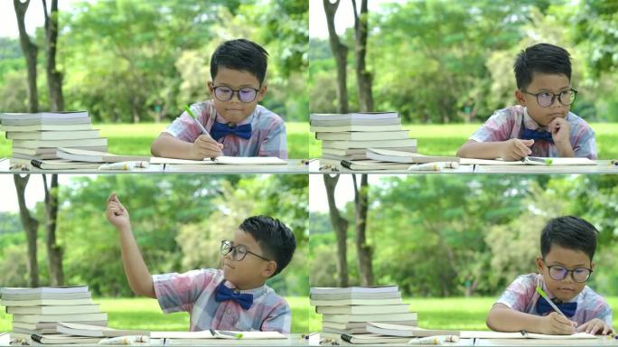 聪明的亚洲小男孩在公园学习，寻找想法或解决方案，复制空间。