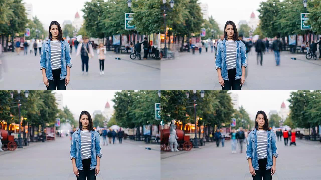 当人们快速走动时，不幸的孤独女孩独自站在街上看着相机。孤独与现代生活观念。