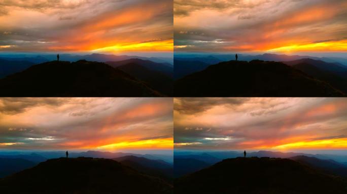 站在山上的男人在美丽的夕阳下