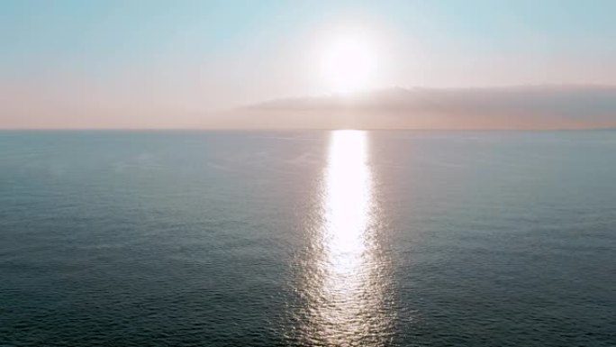 空中4k视图。海上迷人的日落太阳。美丽的电影场景。金色的太阳落在地平线上，飞越水面