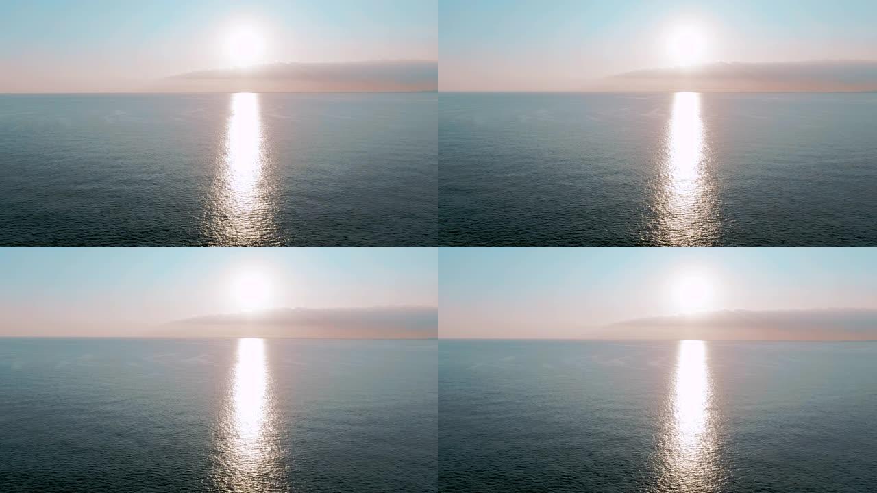 空中4k视图。海上迷人的日落太阳。美丽的电影场景。金色的太阳落在地平线上，飞越水面