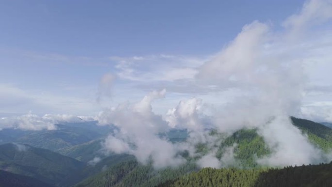 云层背景上风景如画的山脉上的飞行。过度下垂