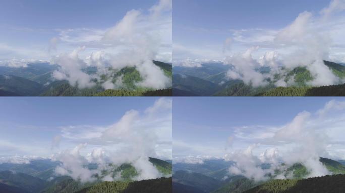 云层背景上风景如画的山脉上的飞行。过度下垂
