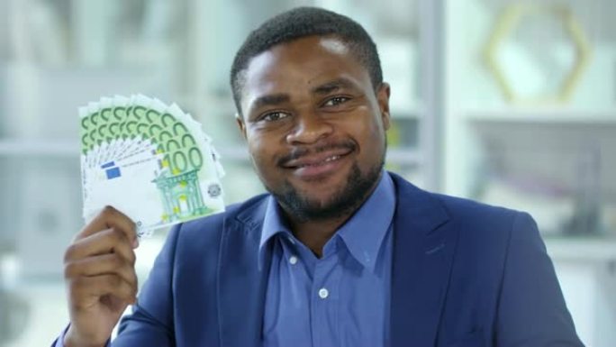 欢乐的非洲商人拿着钞票扇面微笑