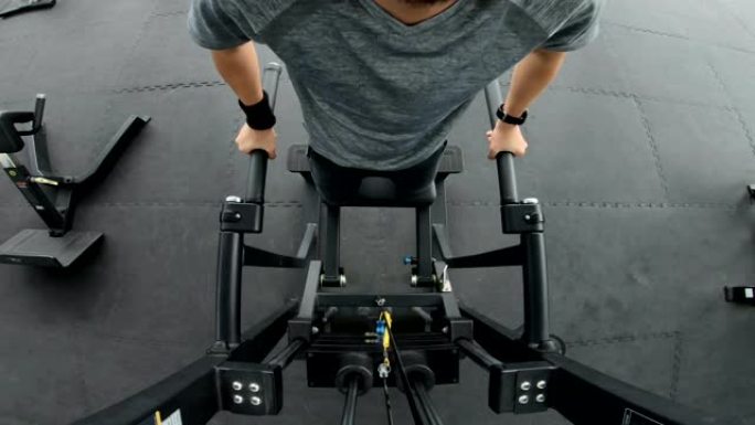 亚洲男子在健身房的三头肌锻炼机上浸泡