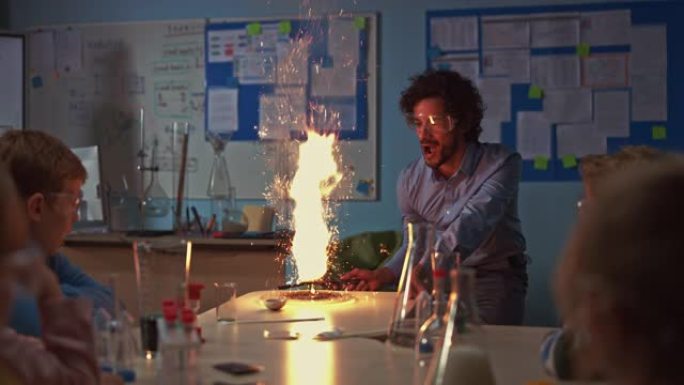 学校化学教室: 全神贯注的孩子们观看热情的老师如何通过点燃火粉来展示科学实验，创造美丽的烟花。孩子们