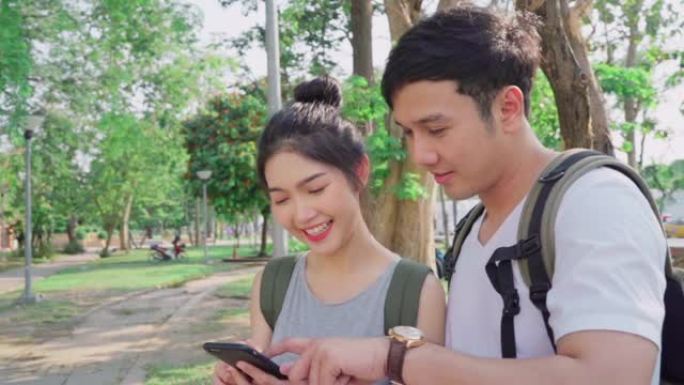 慢动作-旅行者亚洲夫妇在泰国曼谷的位置地图上的方向，夫妇在度假旅行时使用手机在地图上寻找地标。生活方