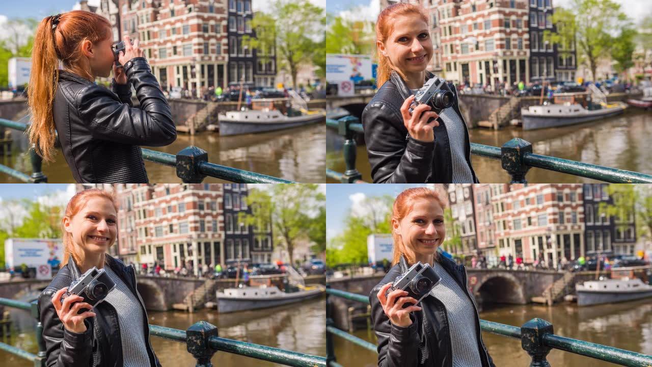 女游客在阿姆斯特丹旅行，用老式模拟相机拍摄运河照片，微笑着进入相机