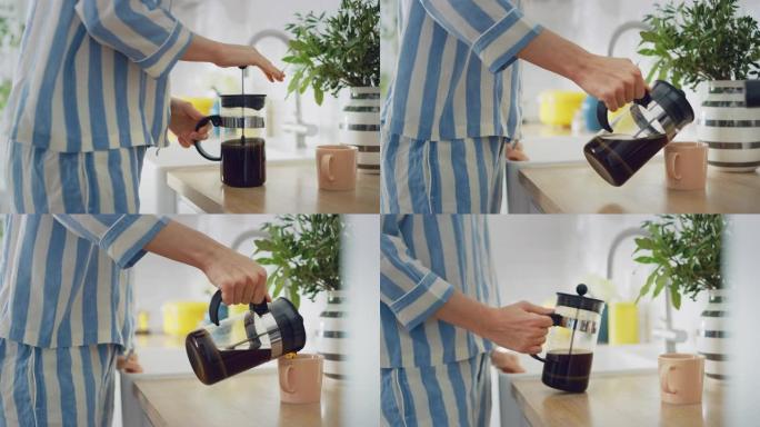 真实的概念，女性在家里的厨房里准备一杯来自法国媒体的新鲜煮咖啡。穿着睡衣，健康创意生活方式的女孩早上