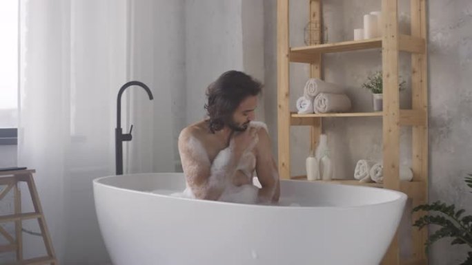 帅哥用海绵洗澡泡沫浴缸洗澡