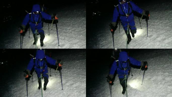 徒步旅行团体走在山上的雪道上。夜晚