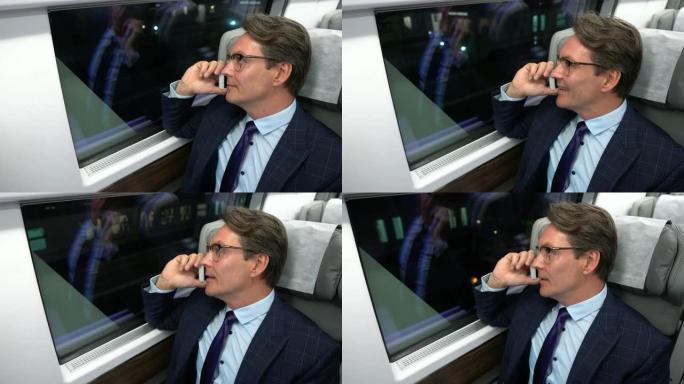英俊的商人在火车上通勤，一边打电话一边看着窗户