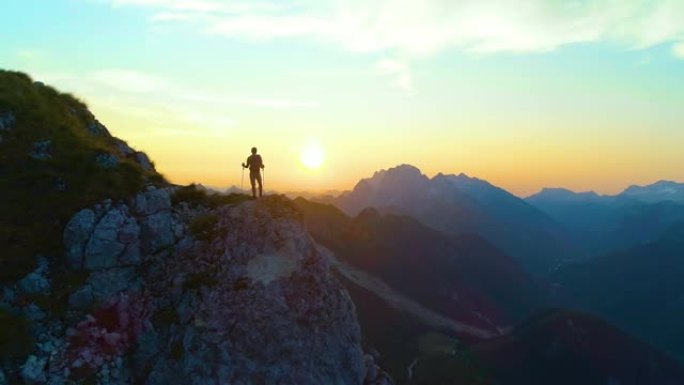 剪影: 无法识别的男性游客在阿尔卑斯山徒步旅行，观察日落。
