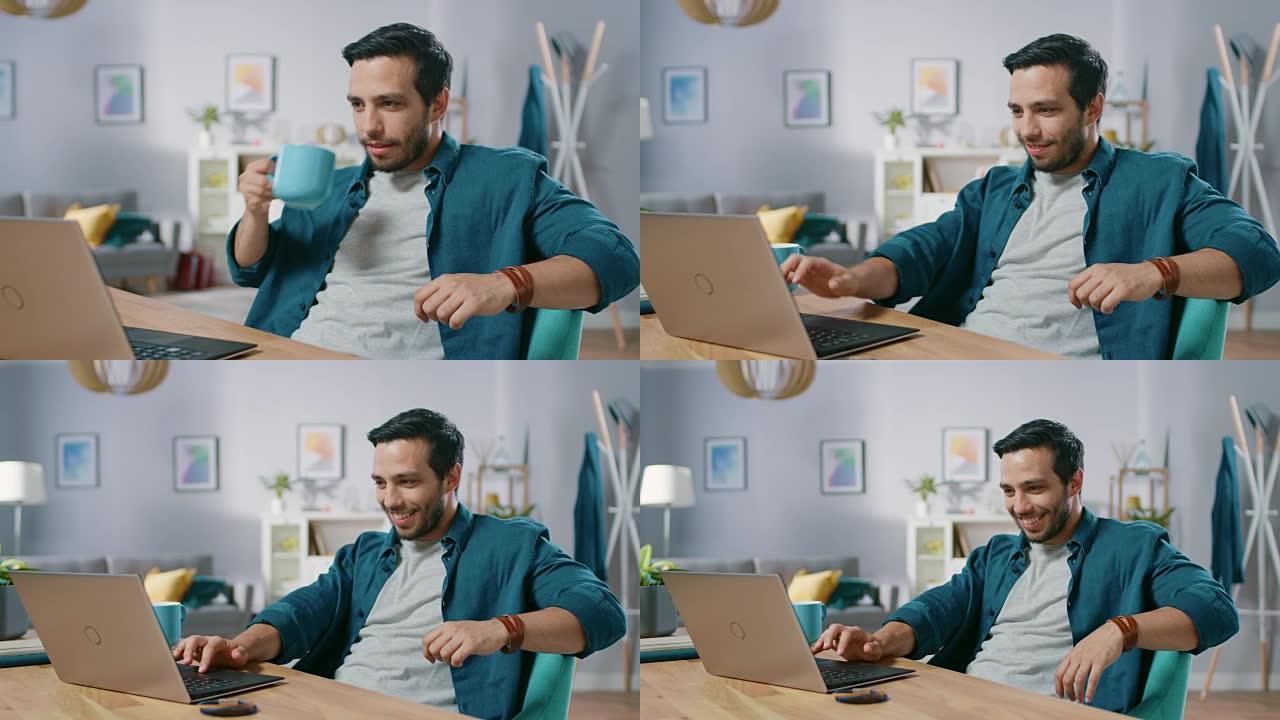 英俊放松的男人坐在家里的办公桌前使用笔记本电脑的肖像。看电影、视频或浏览互联网的人。