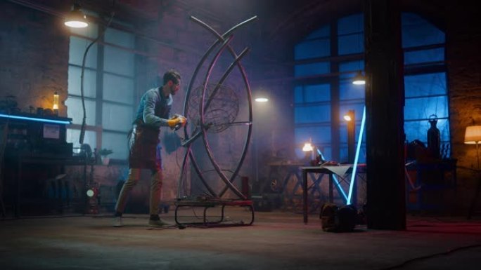 年轻的当代艺术家正在工作室里用手持电动工具打磨他的金属管雕塑。专业人士用金属制作现代残酷的抽象艺术品