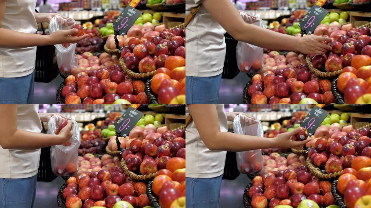 女人选择水果并在超市购物，慢动作
