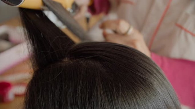 专业美发师为亚洲女性模特制作发型。