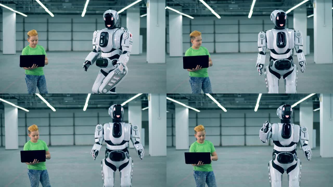 机器人由一个带笔记本电脑的男孩控制