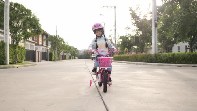 小女孩骑自行车，推动踏板