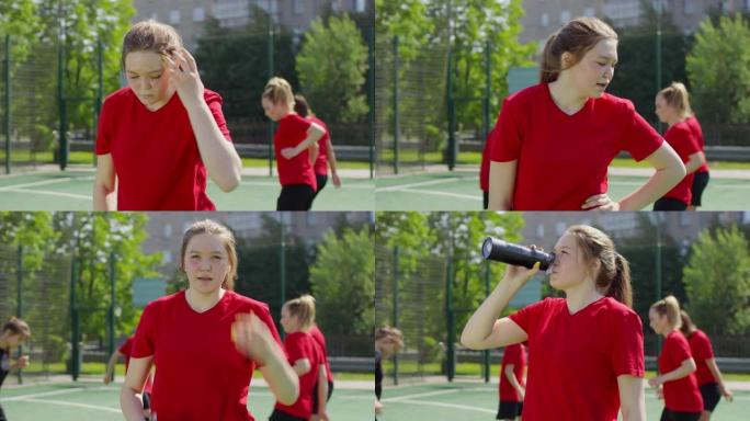 年轻女足球运动员训练后饮水休息