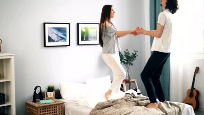 夫妻在公寓的床上跳舞，在卧室里玩得开心