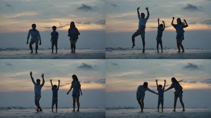 幸福的家庭在日落背景的海滩上跳跃的剪影，慢动作。家庭、自由和旅行理念。