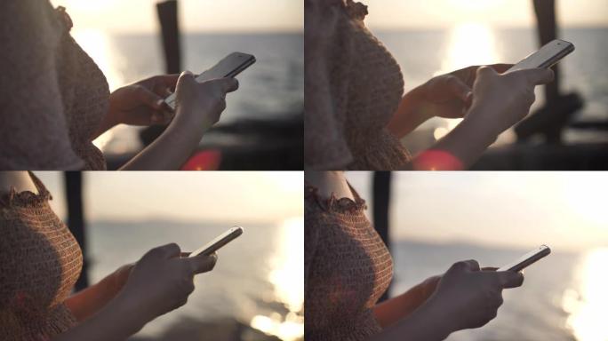 女性双手在智能手机屏幕上敲击消息的特写镜头，以对抗夏季风景