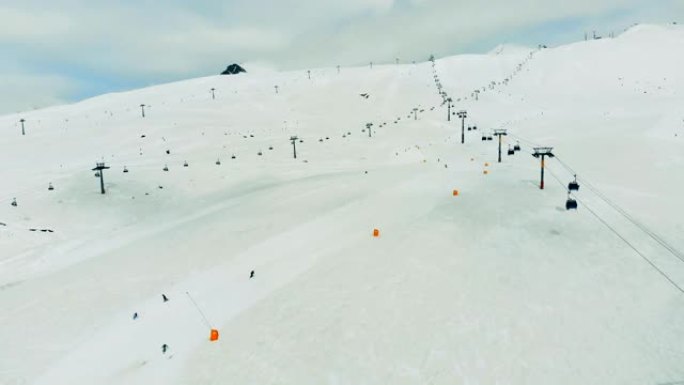 人们和缆车沿着滑雪道行驶