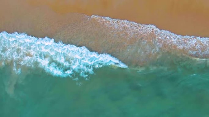 热带沙滩度假海滩的俯视图。慢动作中的海浪。空中4k视图