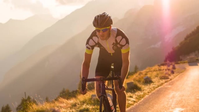 男子公路骑自行车的人在山路上骑自行车，被阳光照亮