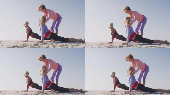 瑜伽老师在海滩上向高级女性教授瑜伽