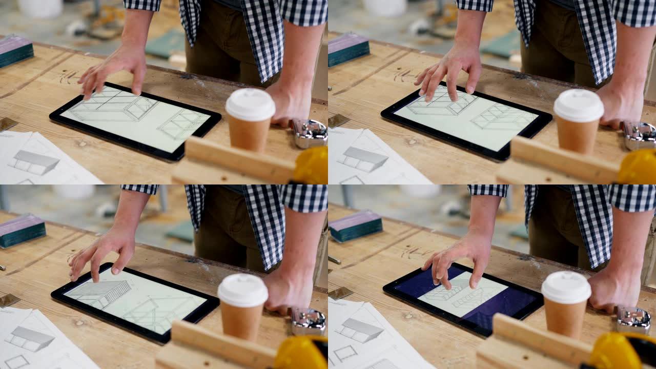 男木匠在平板电脑屏幕上看家具的技术图纸