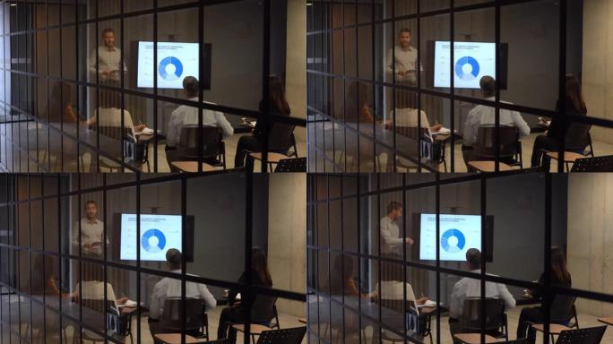 男子在商务会议上使用视觉辅助工具向他的团队讲话