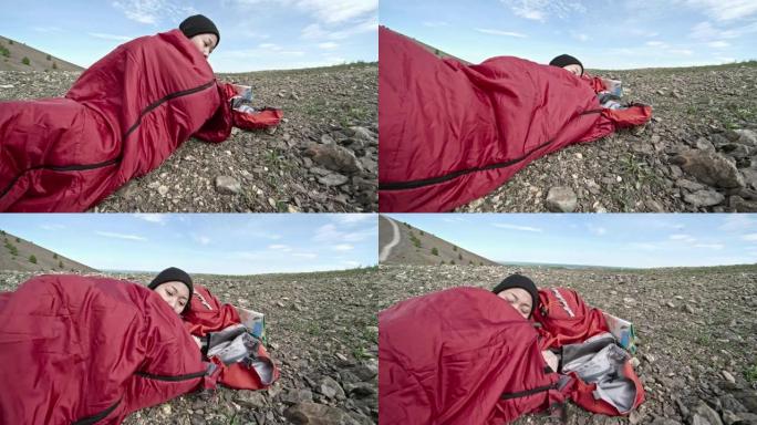 女人徒步旅行者在睡袋中休息