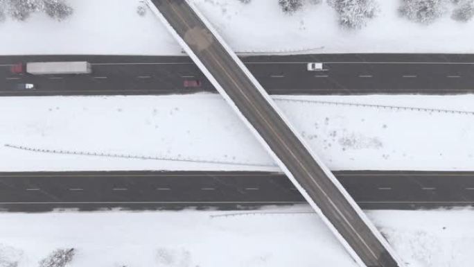 自上而下: 在一场强烈的暴风雪中，在美国的高速公路立交桥上方飞行。