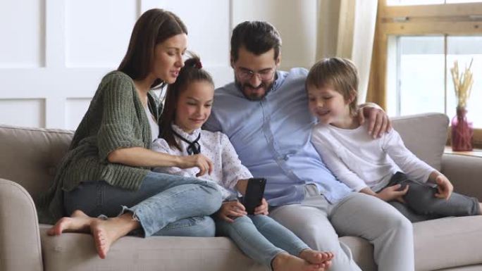 幸福的家庭使用移动应用程序，一起享受休闲时光。