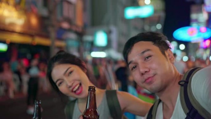 旅行者亚洲博主夫妇在泰国曼谷旅行，甜蜜的夫妇使用手机制作vlog并在社交媒体上生活，同时在考山路闲逛
