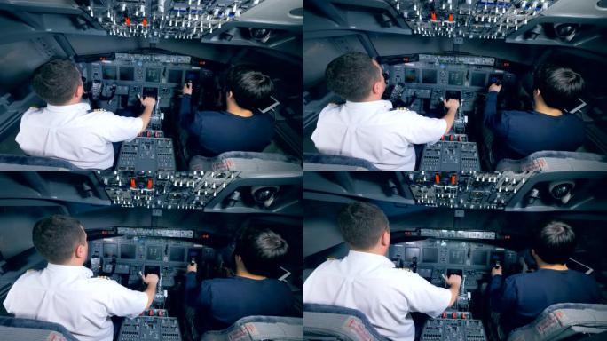 两名飞行员将飞机降落在模拟器中，后视图。