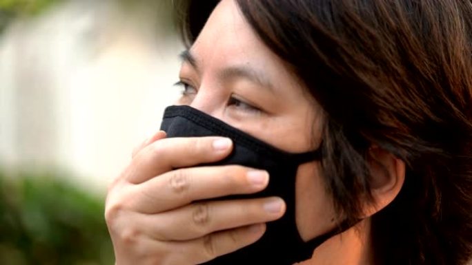 侧视病妇在空气污染面具下咳嗽