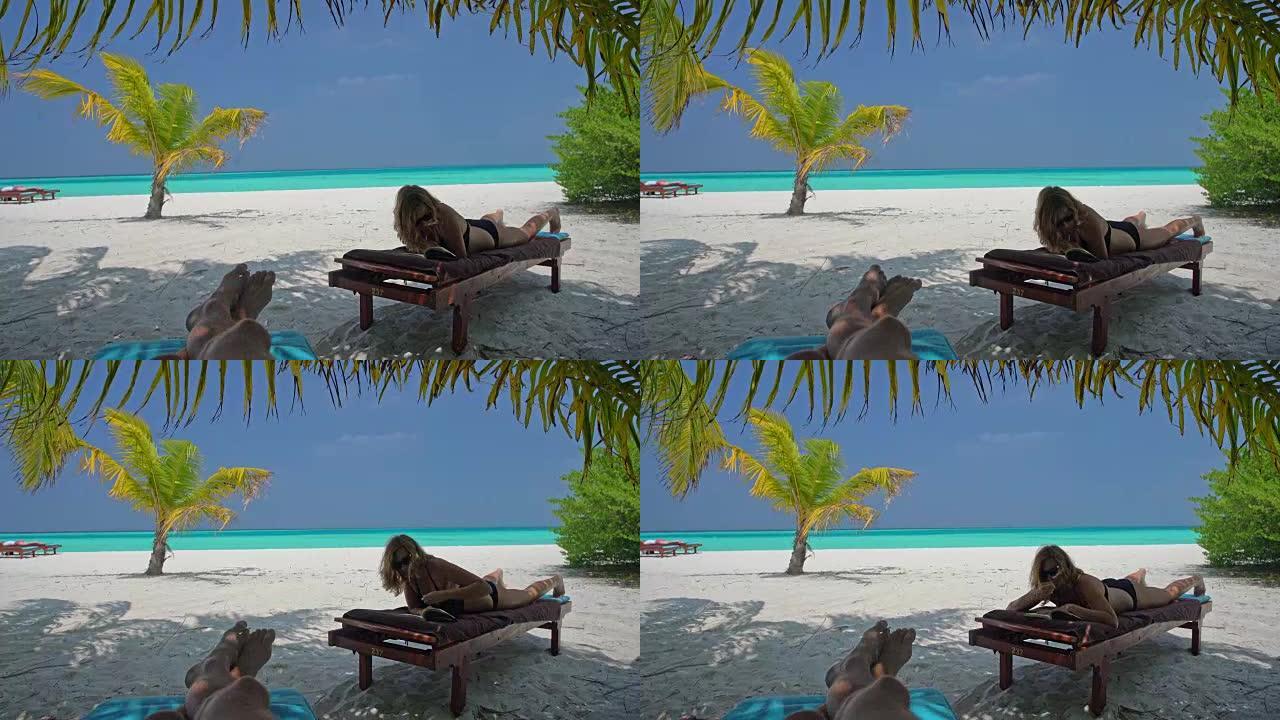 女士放松，马尔代夫热带海洋海滩田园诗般的躺椅上看书