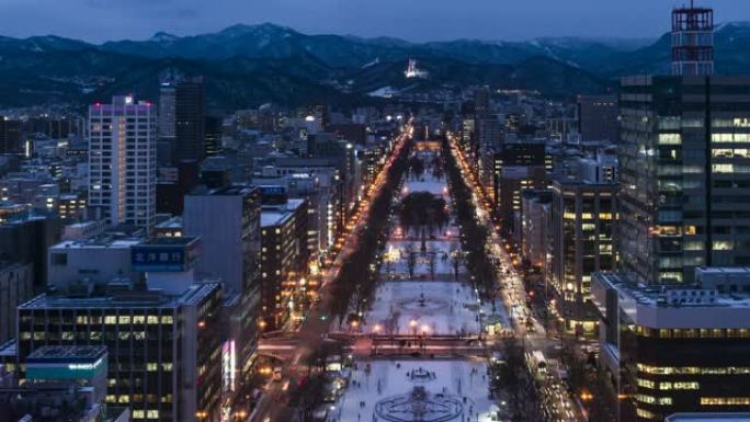 札幌电视塔的大通公园俯视图，黄昏时商业区有红绿灯。从左到右平移。