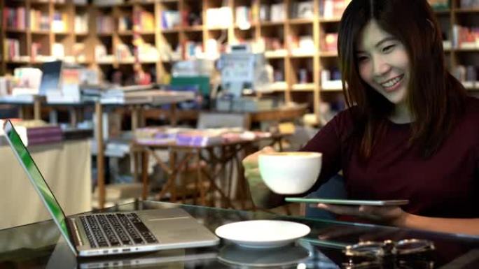 4k镜头场景亚洲女商人使用平板电脑和绿屏笔记本电脑的特写镜头，在咖啡馆喝咖啡，生活方式和商业概念
