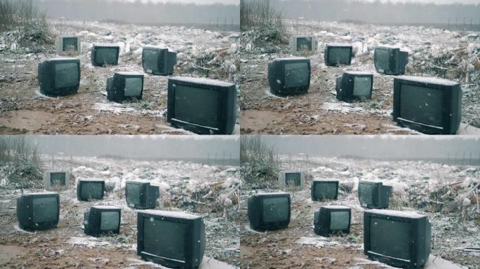 下雪时垃圾填埋场上的旧电视。