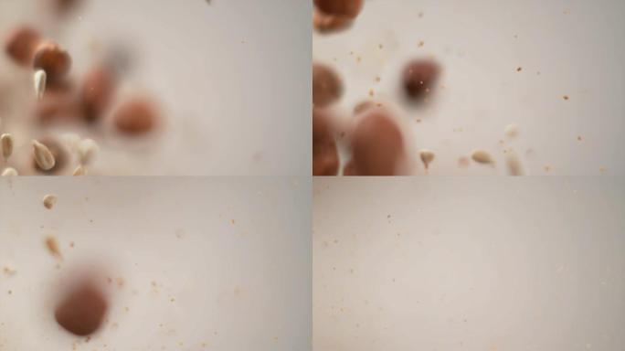 慢动作: 坚果和棕色小颗粒爆炸进入相机的凉爽镜头。