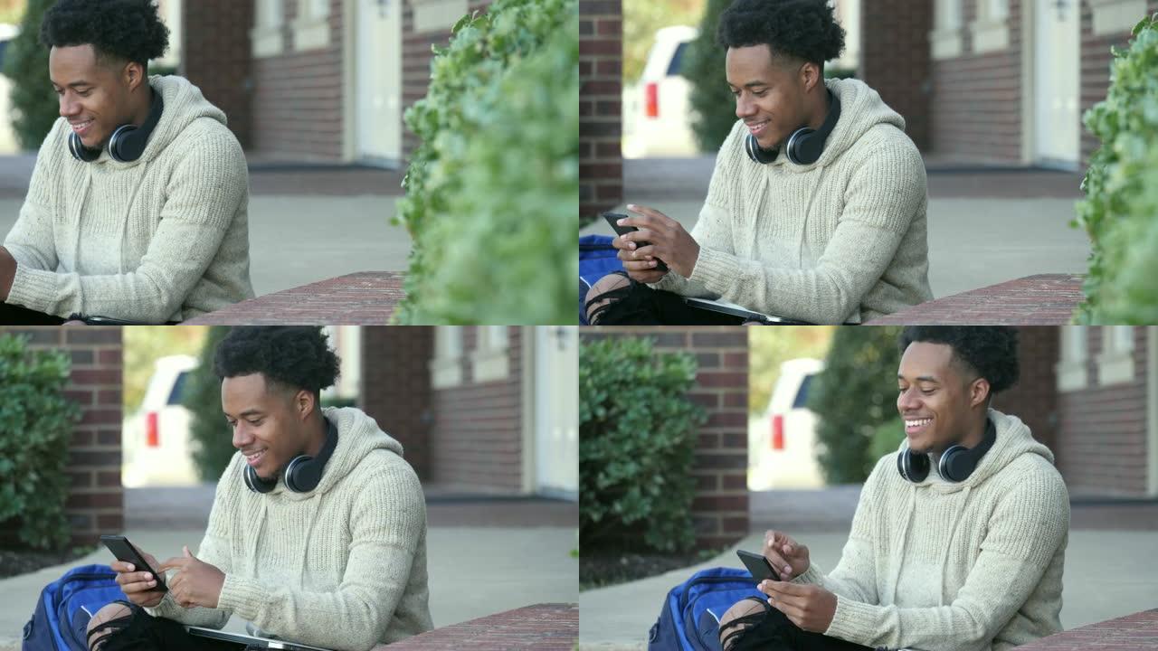 帅气男大学生在等课时使用智能手机