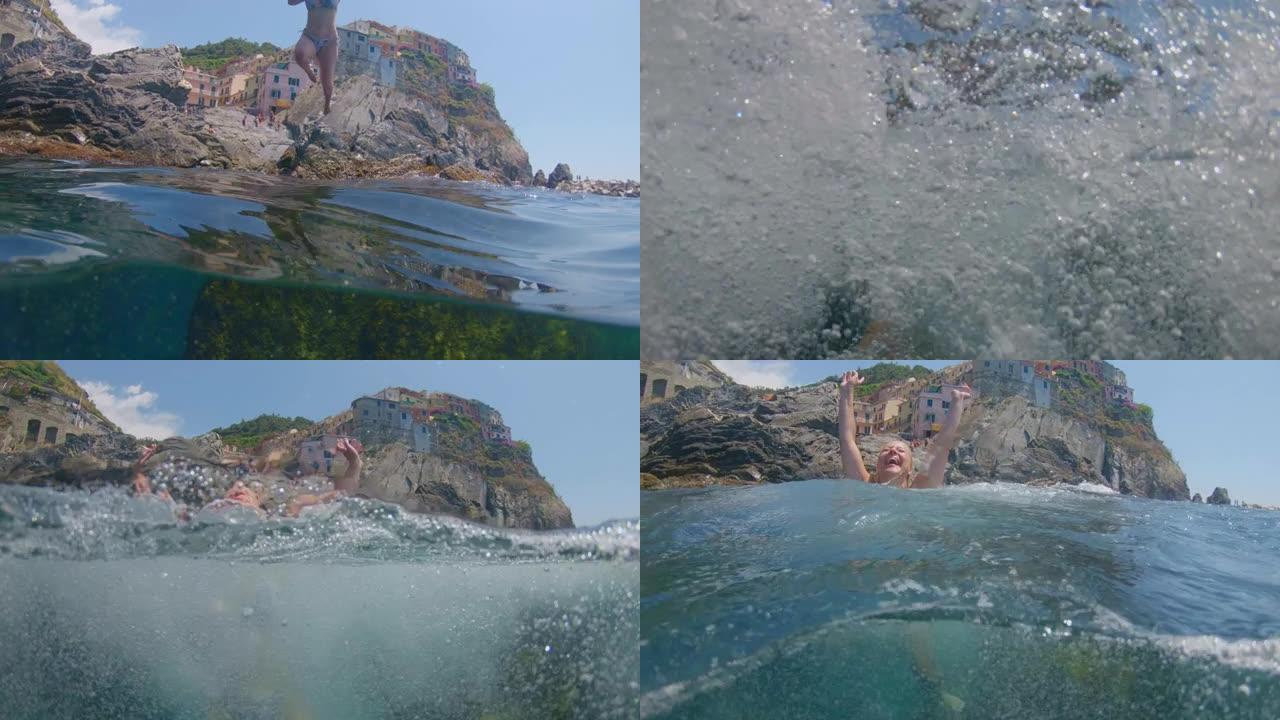 WS无忧无虑的年轻女子跳入阳光明媚的大海，五渔村，意大利